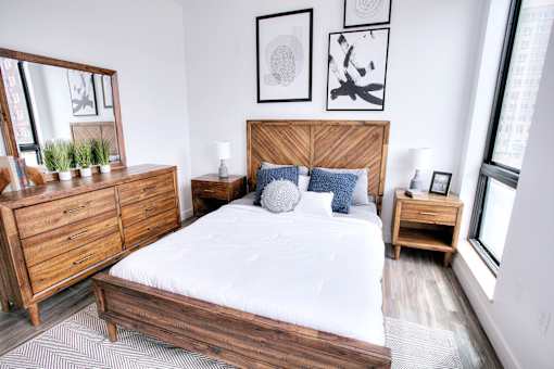 A bedroom with a large bed, wooden furniture, and a mirror.