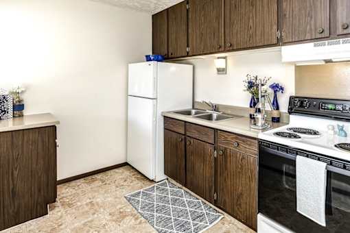 A kitchen with a white fridge and black stove.