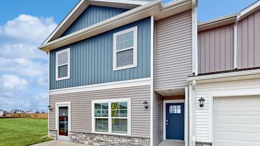 A house with a blue and grey exterior and a white garage door.