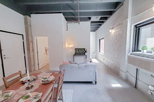 A dining room with a wooden table set for two.