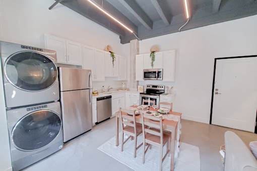 A modern kitchen with a dining table and chairs.