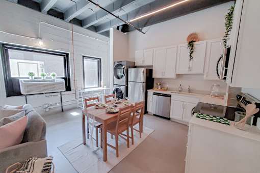A kitchen with a table and chairs in the middle of the room.