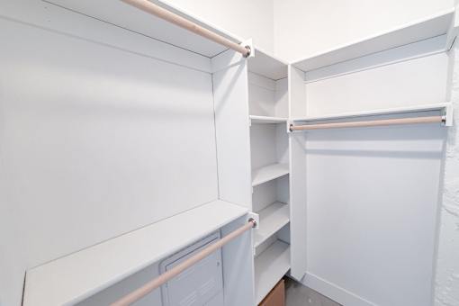 A white closet with shelves and hangers.