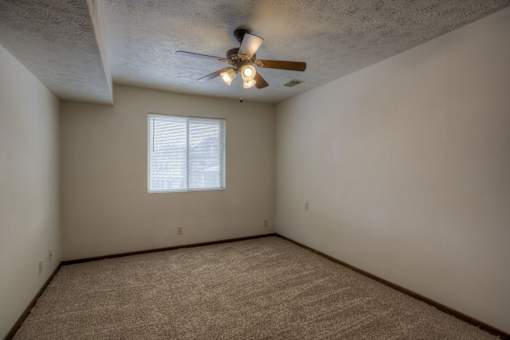 A room with a ceiling fan and a window.