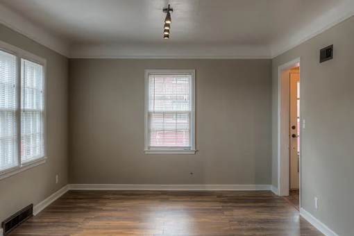 A room with a window and wooden flooring.