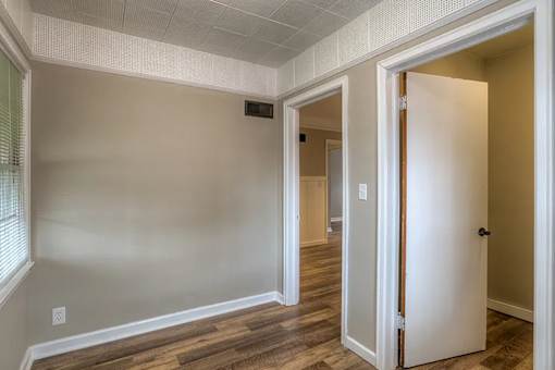 A room with a white door and a window with blinds.