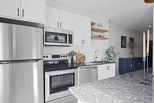 A modern kitchen with a refrigerator, oven, microwave, and sink.