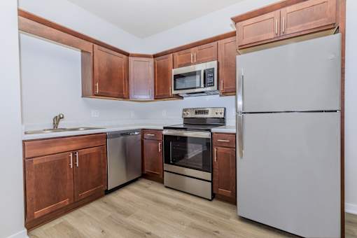 A kitchen with wooden cabinets and stainless steel appliances.