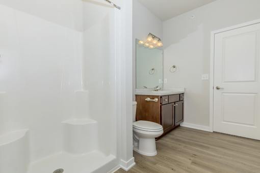 A white bathroom with a toilet and a mirror.