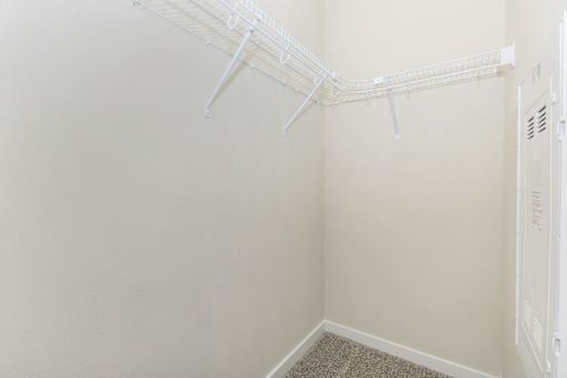 A white closet with a white hanger.