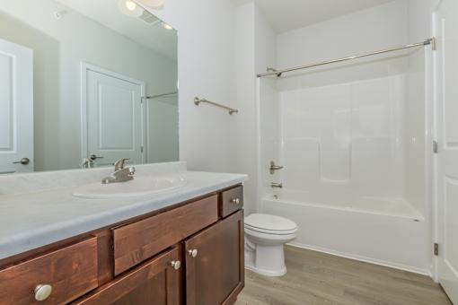 A bathroom with a white toilet and a white bathtub.