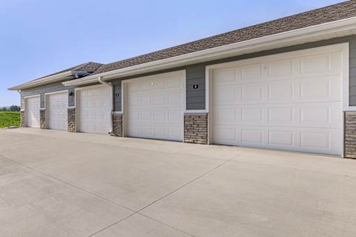 A row of garage doors in front of a house.