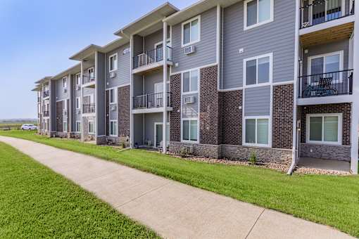 A row of apartment buildings with balconies and doors.