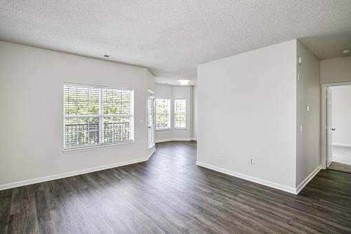 A spacious room with wooden floors and white walls.