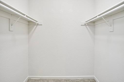A white hallway with a carpeted floor and white walls.