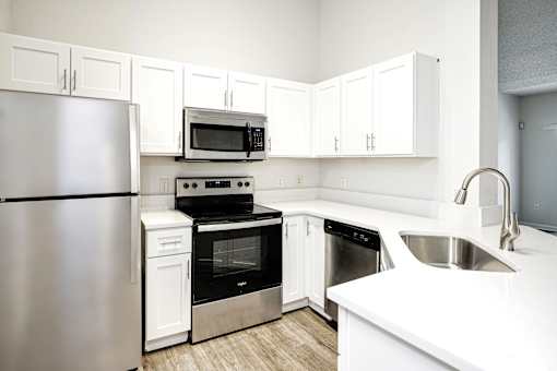 A kitchen with white cabinets and appliances.