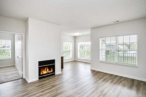 A living room with a fireplace and a view of the backyard.
