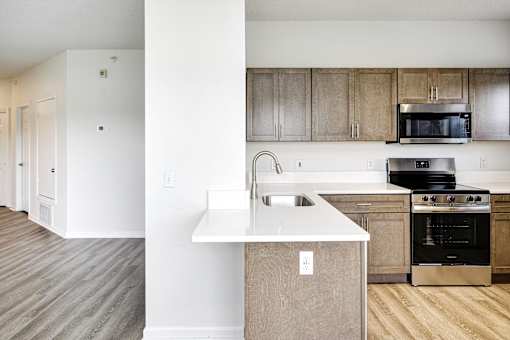 A kitchen with a white counter top and wooden cabinets.