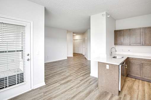 A kitchen with a sink and a window with blinds.