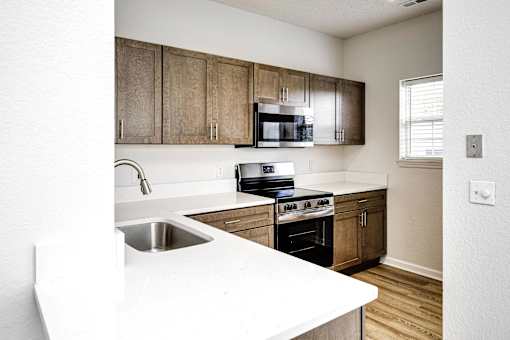 A kitchen with wooden cabinets and white countertops.
