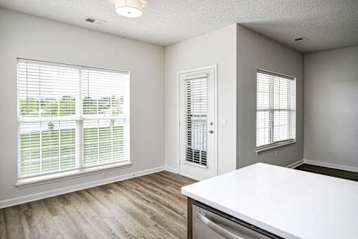 A room with a white countertop and wooden flooring.