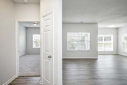 A room with a carpeted floor and a door leading to another room.