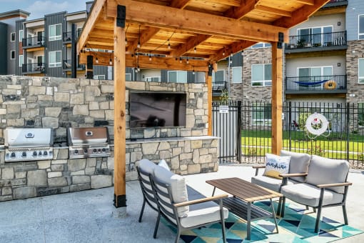 Outdoor seating area with tv and grills at AXIS apartments in Papillion, NE