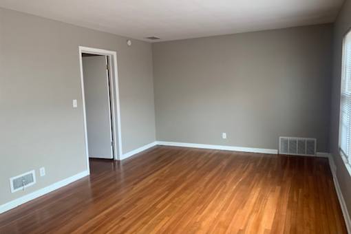 A room with wooden floors and a door.