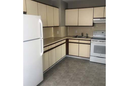 A kitchen with a white refrigerator, white oven, and white microwave.