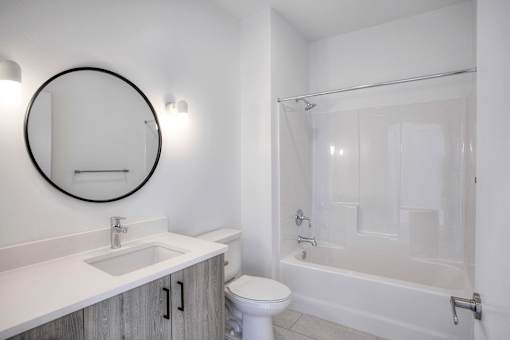 A white bathroom with a toilet, sink, and bathtub.