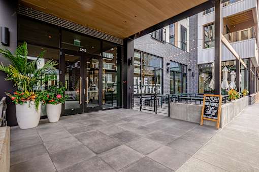 A modern building entrance with a glass door and a sign that reads "SWITCH".