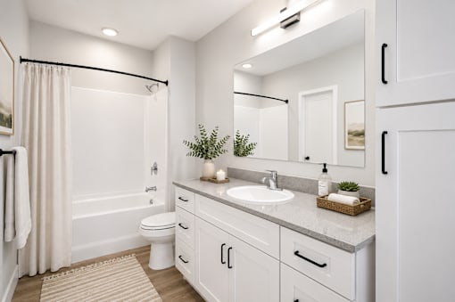 A white bathroom with a toilet, sink, and shower.