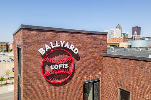 A red sign on a brick building that says Ballyard Lofts.