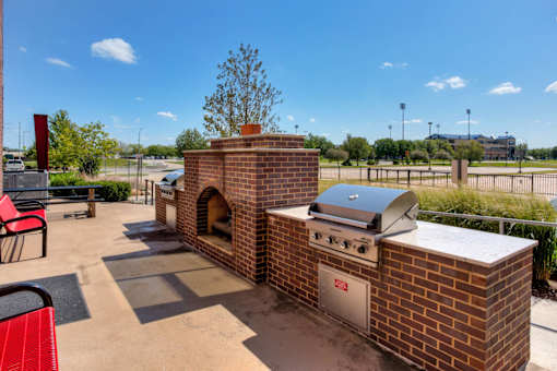 A brick oven is in the middle of a patio.