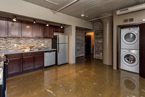 A kitchen with a refrigerator and a washing machine.