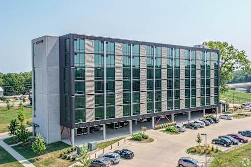 A modern building with a parking lot in front.