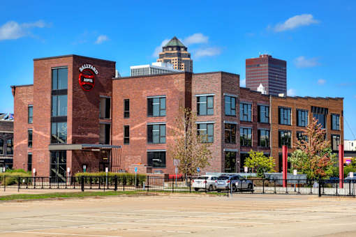 A large brick building with a red sign on it.