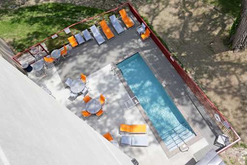 An aerial view of a pool with chairs around it.