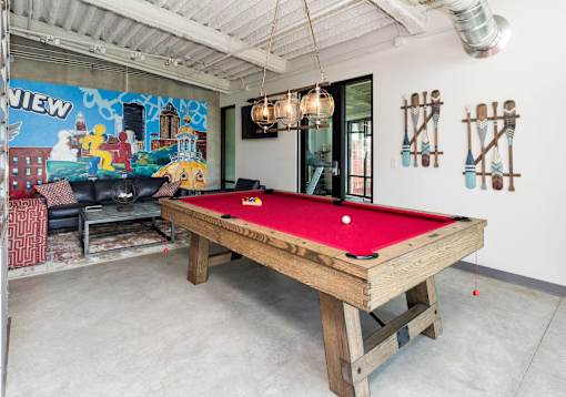 A pool table in a room with a mural on the wall.