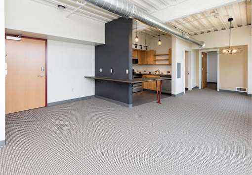 A large open room with a kitchenette and a dining table.