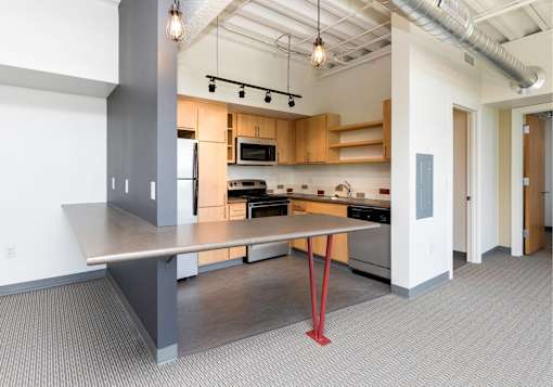 A kitchen with a table and a refrigerator.