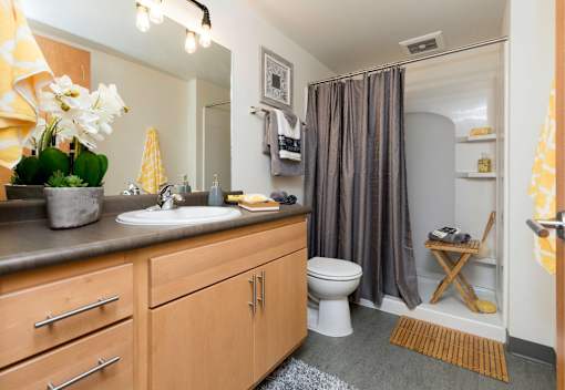 A bathroom with a toilet, sink, and shower.