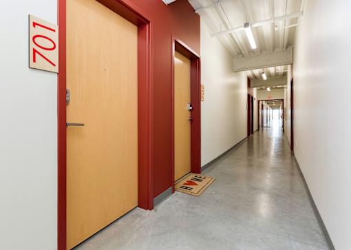 A hallway with a red door and a sign that says 101.