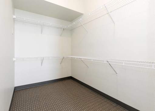 Empty room with white walls and brown carpet.