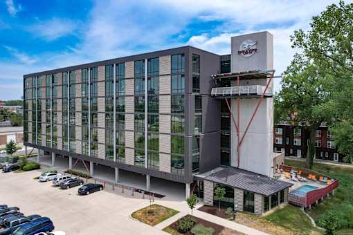 A modern building with a parking lot in front.