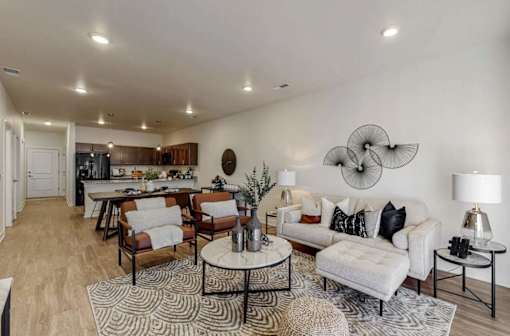 A living room with a white couch and a patterned rug.
