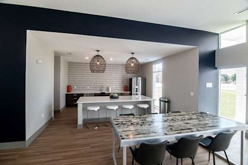 A modern kitchen with a large island and a dining table set for four.