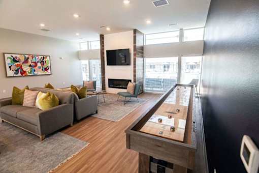 A living room with a couch, a chair, a coffee table, and a television.