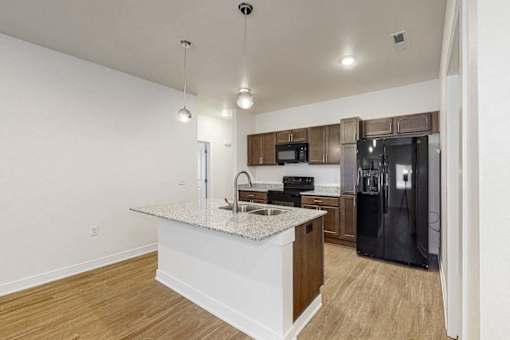 A kitchen with a granite countertop and a refrigerator.