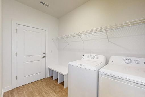 A white laundry room with a washer and dryer.